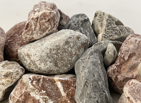 Detalle de piedras de río naturales con vetas y colores variados para voladera