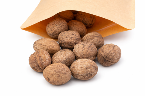 Nueces naturales para loros saliendo de bolsa de papel kraft