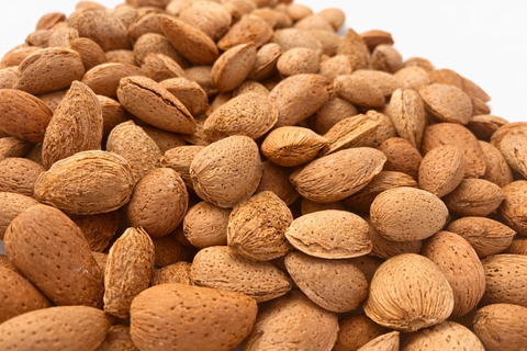 Detalle de almendras naturales con cáscara para forrajeo de loros